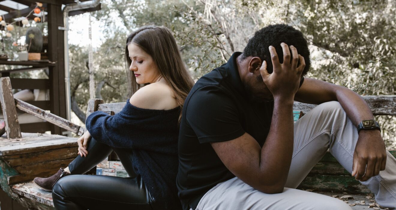 Pareja en un banco al aire libre mostrando distancia emocional