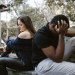 Pareja en un banco al aire libre mostrando distancia emocional